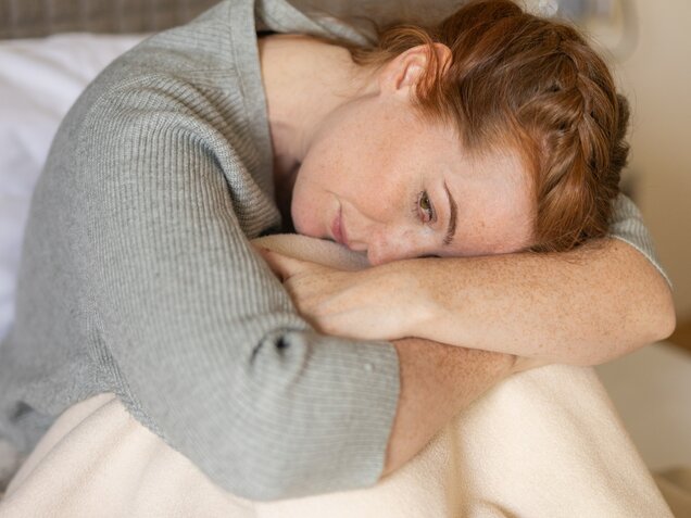 Nachdenkliche Frau mit langen roten Haaren – Moment der Selbstreflexion im Park Igls Medical Spa Resort