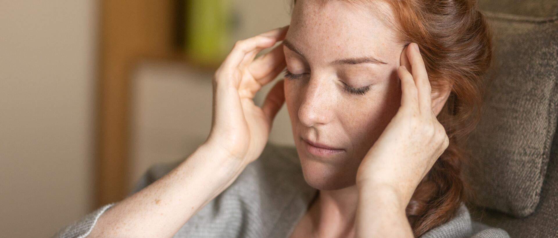 Nachdenkliche Frau mit langen roten Haaren – Moment der Selbstreflexion im Park Igls Medical Spa Resort