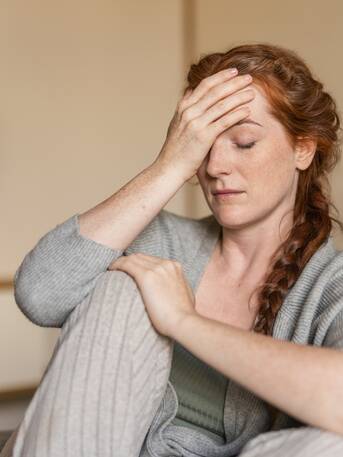 Nachdenkliche Frau mit langen roten Haaren – Moment der Selbstreflexion im Park Igls Medical Spa Resort