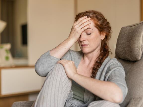 Nachdenkliche Frau mit langen roten Haaren – Moment der Selbstreflexion im Park Igls Medical Spa Resort