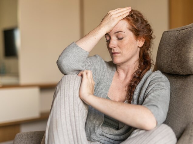 Nachdenkliche Frau mit langen roten Haaren – Moment der Selbstreflexion im Park Igls Medical Spa Resort