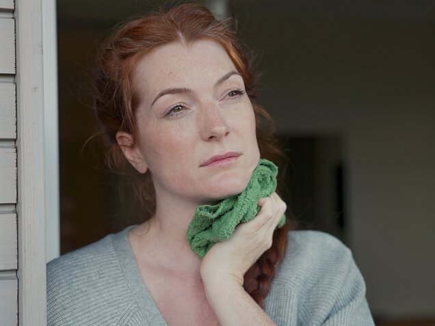 Nachdenkliche Frau mit langen roten Haaren – Moment der Selbstreflexion im Park Igls Medical Spa