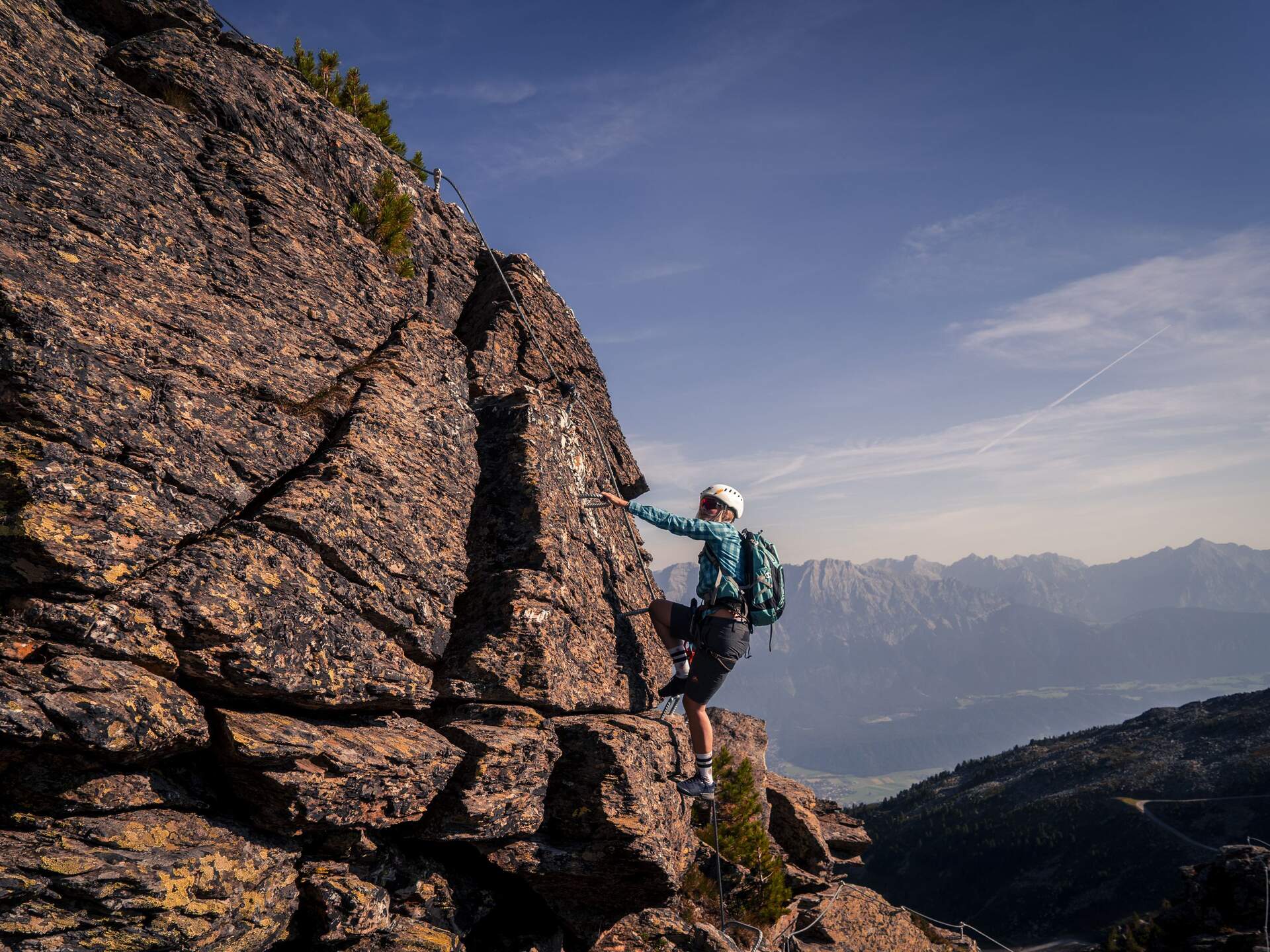 Kletterer am Fels mit Klettersteig-Sicherung, Bergpanorama im Hintergrund | © Tourismusverband Hall-Wattens