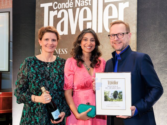 Drei Personen präsentieren stolz eine Auszeichnung vor einem Condé Nast Traveller Banner