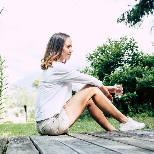 Frau sitzt im Gras und genießt 